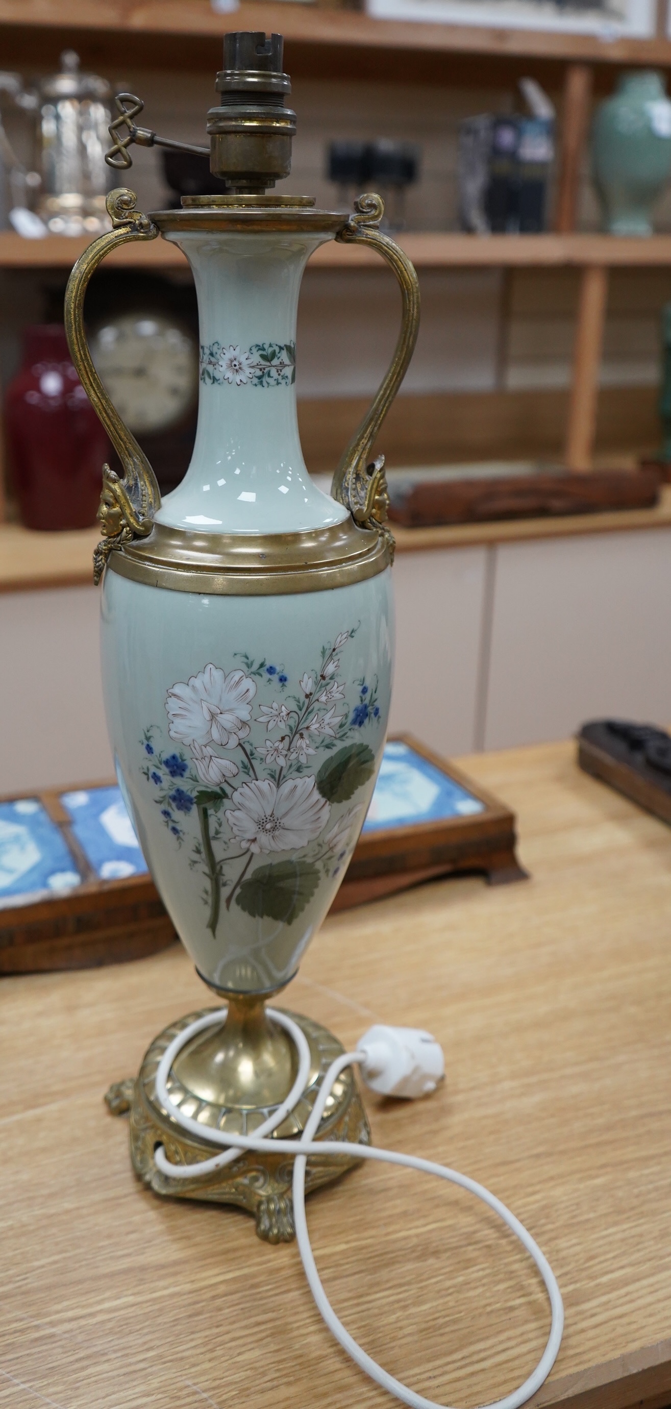 A late 19th century French celadon green glazed lamp, painted with flowers, fitted as a lamp, 56cm high overall. Condition - good